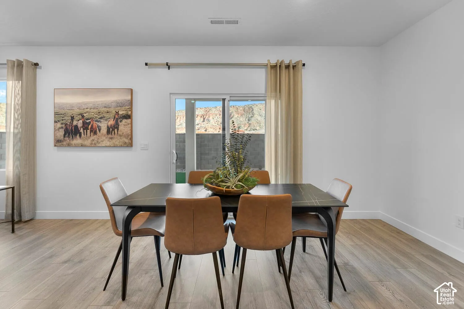 Light wood-finish flooring, white walls, and a sliding glass door offering natural light