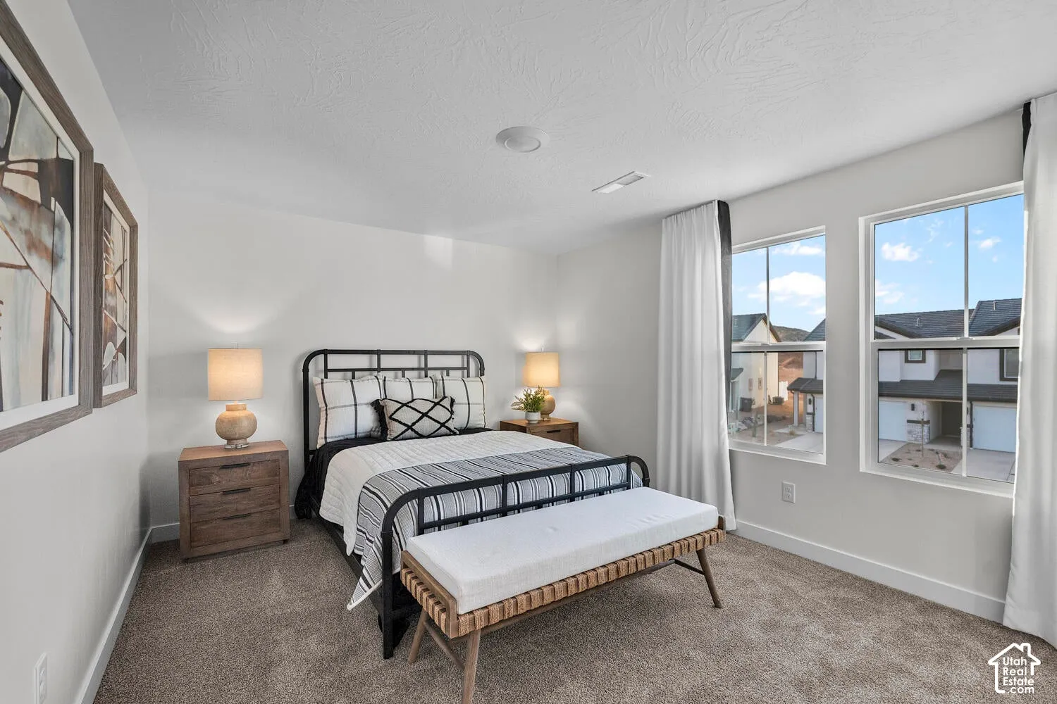Carpeted flooring, white walls, two large windows, white window trim, and a recessed ceiling light