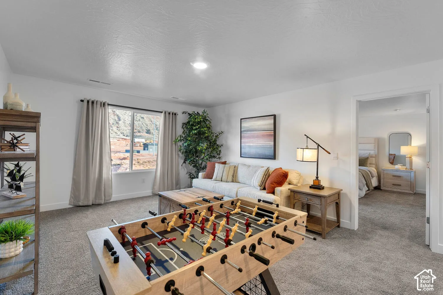 Carpeted living space featuring a window with exterior views, recessed lighting, and an open doorway