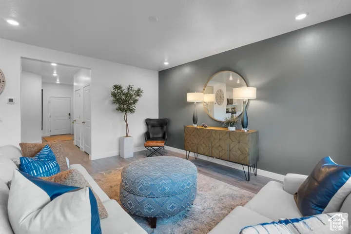 Recessed lighting, wood-finish flooring, two-panel interior doors, and a decorative accent wall
