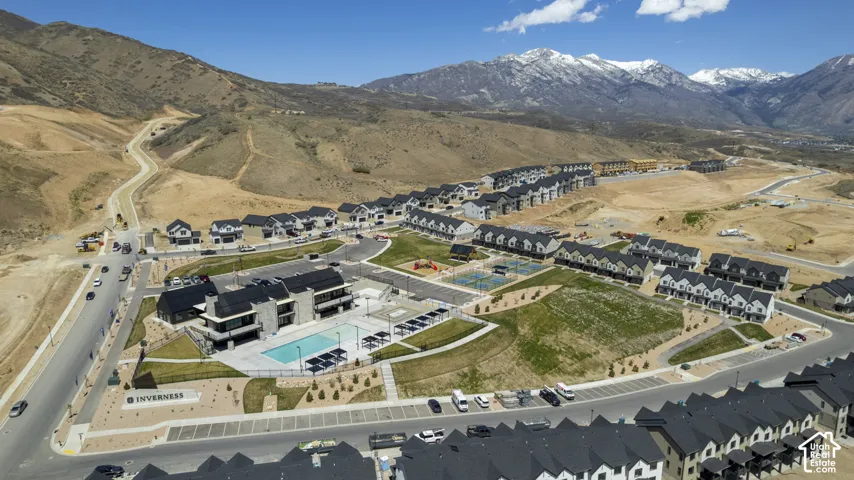 Planned community featuring residential buildings, a central amenity building with a swimming pool, and multiple sports courts
