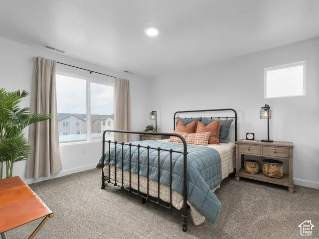 Recessed ceiling lighting, a large window with roller shades, and a second square window provide ample illumination