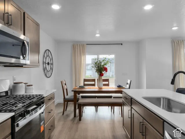 Kitchen featuring stainless steel appliances, recessed lighting, wood-finish flooring, and white countertops