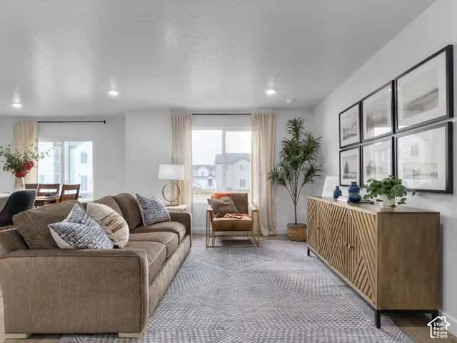 Open-concept living space featuring wood-finish flooring, recessed lighting, and large windows