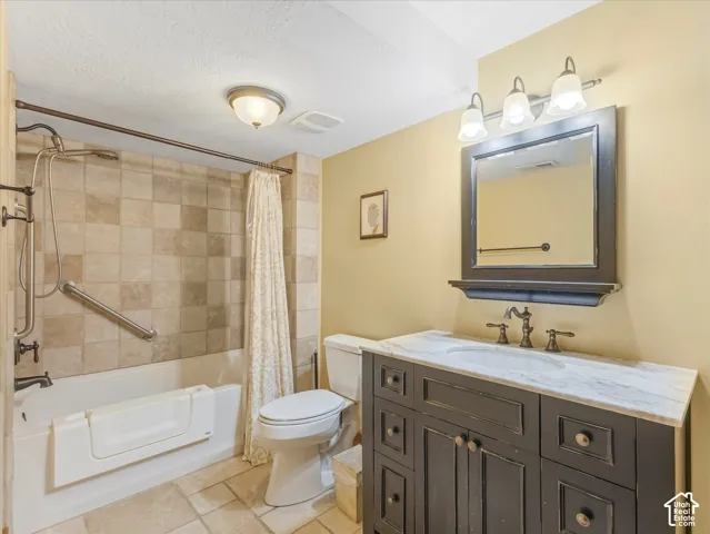 Tub with shower features a tiled surround and grab bar