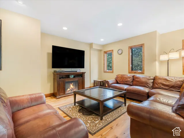 Wood-finish flooring, recessed lighting, and a built-in electric fireplace