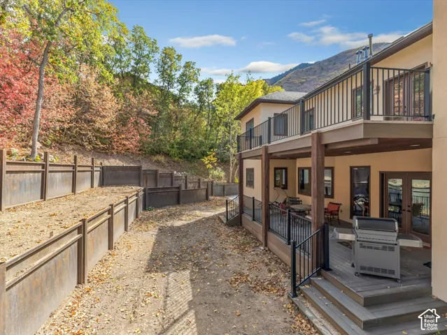 Multi-level exterior deck featuring composite decking, black metal railings, and mountain backdrop