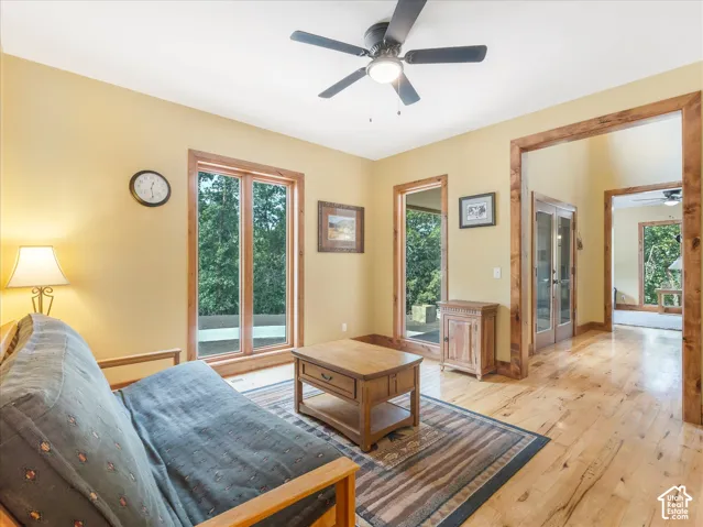 Hardwood flooring, wood-framed windows, wood archways, wood-framed double doors, ceiling fan with integrated lighting