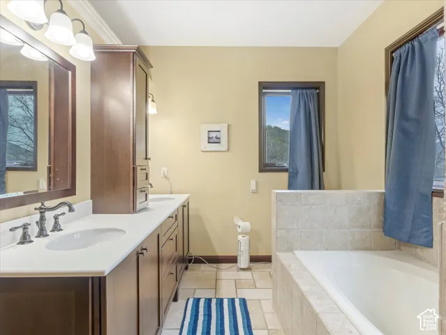 Dual vanity with white undermount sinks, bronze finish faucets, and white countertops