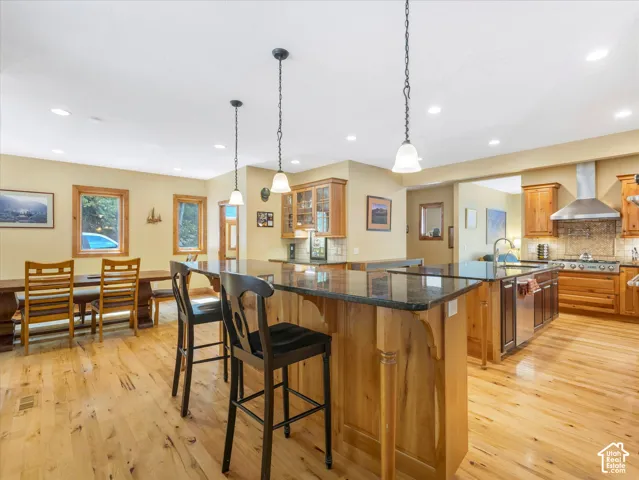 Spacious kitchen featuring wood-finish flooring, recessed lighting, and a kitchen island with stone countertops