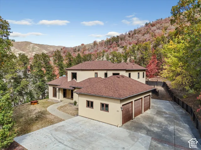 Multi-level stucco exterior with a hipped roof and an attached three-car garage