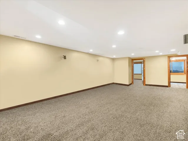 Spacious room with recessed lighting, light-toned wall paint, and carpet flooring