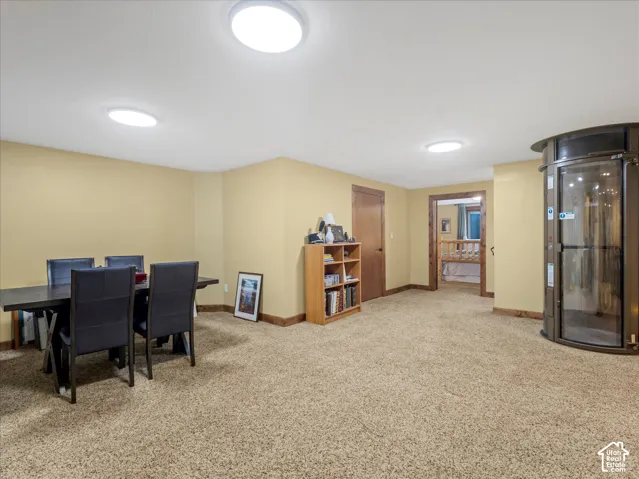 Spacious room featuring carpet flooring, recessed lighting, and a built-in circular elevator