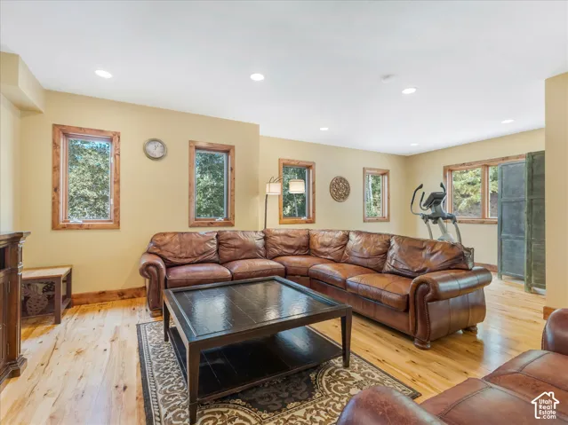 Recessed lighting, wood-finish flooring, and multiple windows with wood trim