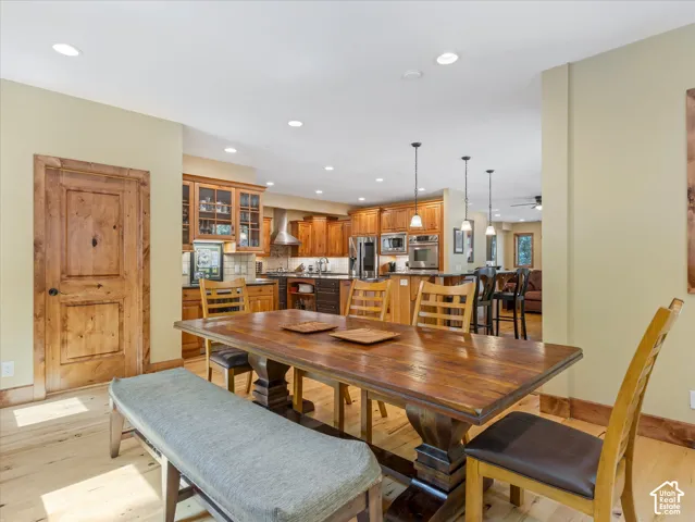 Open-concept kitchen and dining area featuring wood-finish flooring, recessed lighting, and pendant lighting
