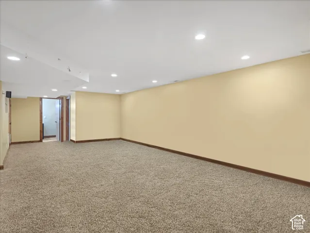 Spacious room featuring neutral carpeting and recessed lighting
