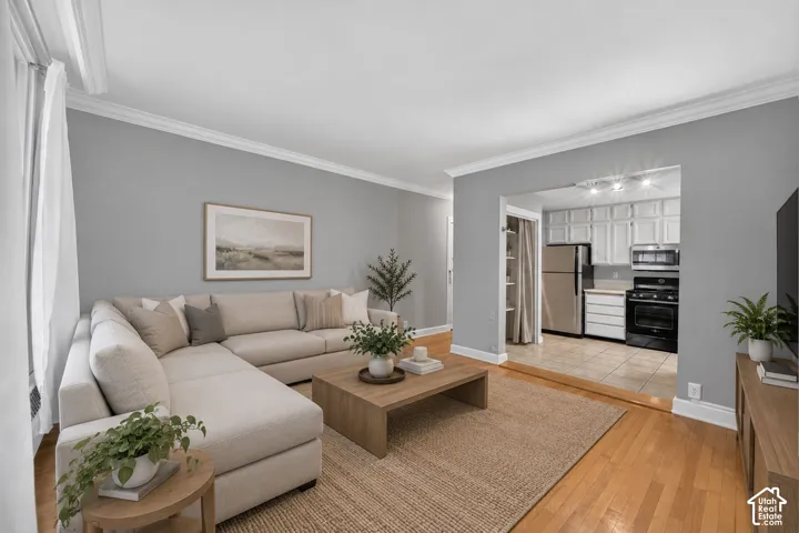 Spacious living area with a sectional layout, hardwood flooring, and neutral gray walls