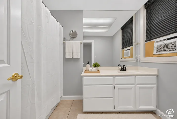 White vanity with a light-toned countertop, integrated sink, and matte black faucet