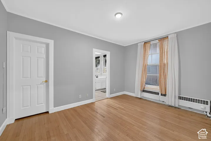 Hardwood flooring, painted walls, white trim, recessed lighting, and a multi-pane window