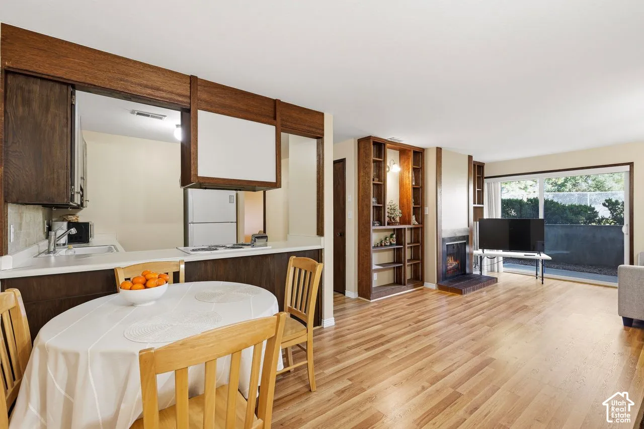 Open concept living area with wood-finish flooring, built-in shelving, gas fireplace and sliding glass doors