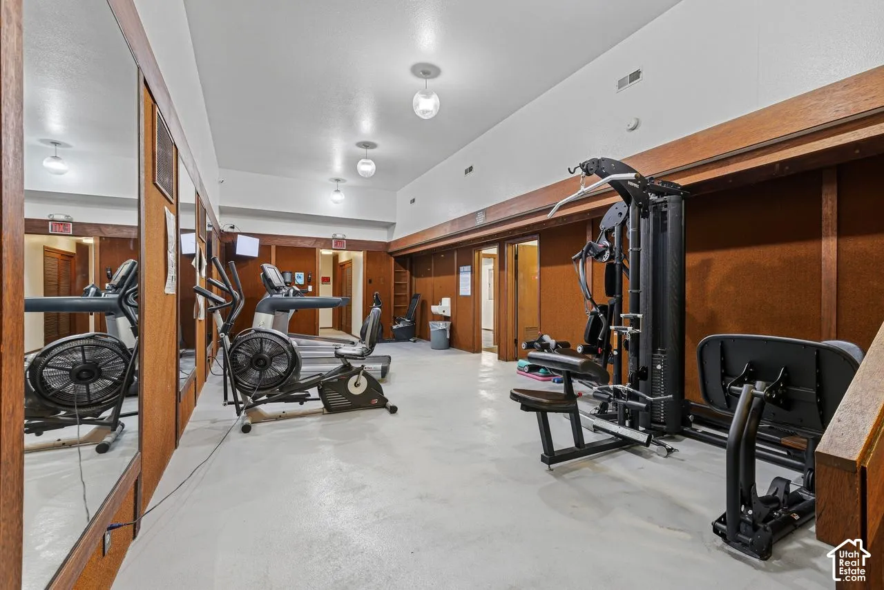 Dedicated fitness space featuring full-length mirrors, recessed ceiling lights,