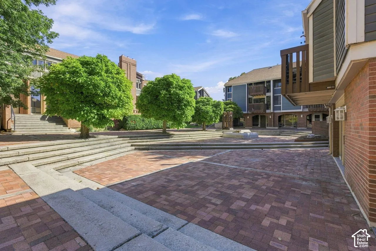 Paver courtyard with mature trees and concrete steps