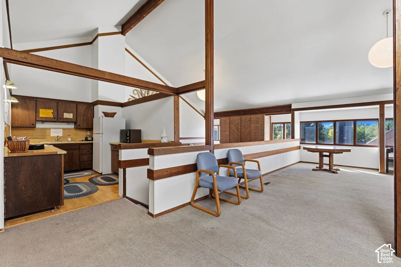 Club house kitchen,Open concept area featuring vaulted ceilings, exposed wood beams, a kitchen with wood cabinetry