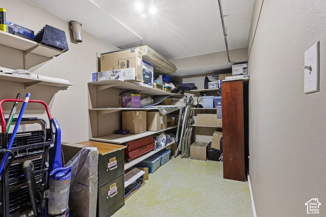 Interior storage and utility room area featuring light-toned walls, overhead lighting, and built-in shelving units