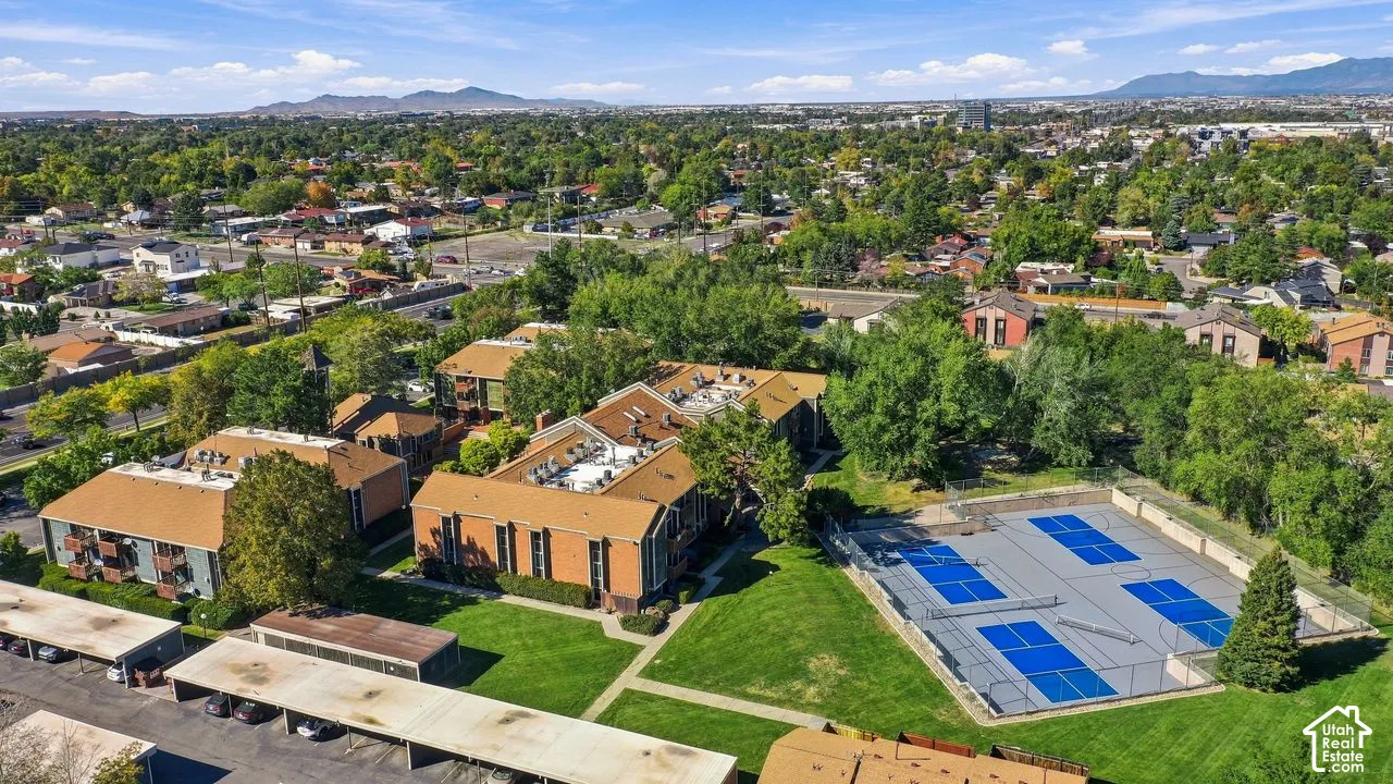 Multiple multi-story buildings, extensive green spaces, dedicated sports courts, covered parking structures, and mature landscaping