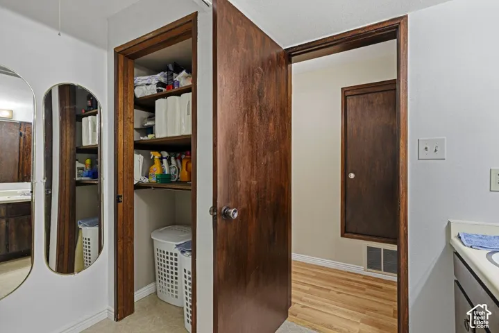 White painted walls with wood-finish trim, wood-finish doors, and a built-in closet with wood-finish shelving