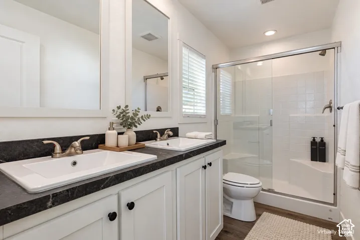 Dual vanity with a dark countertop, white cabinetry, and brushed nickel fixtures