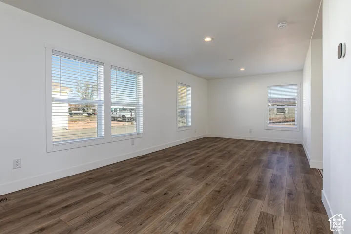 Recessed lighting, wood-finish flooring, white window frames, horizontal blinds, and a neutral color palette