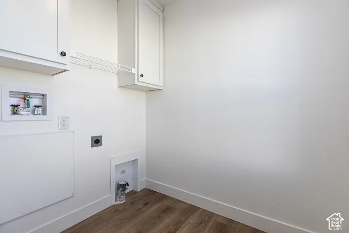 Efficient utility space featuring clean white cabinetry, wood-finish flooring, and practical built-in storage