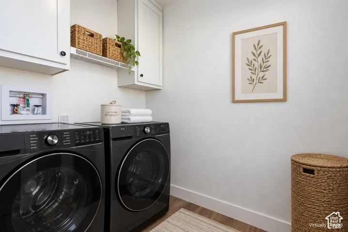 Washer and Dryer do not convey with property. White upper cabinetry, white wire shelving, wood-finish flooring, and crisp white walls