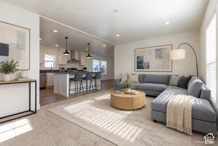 Recessed lighting, wood-finish flooring, and white walls create a bright and airy atmosphere