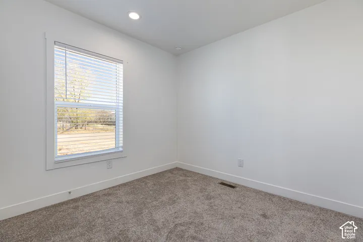 Recessed ceiling lighting, white walls, white window trim, white blinds, and carpeted flooring