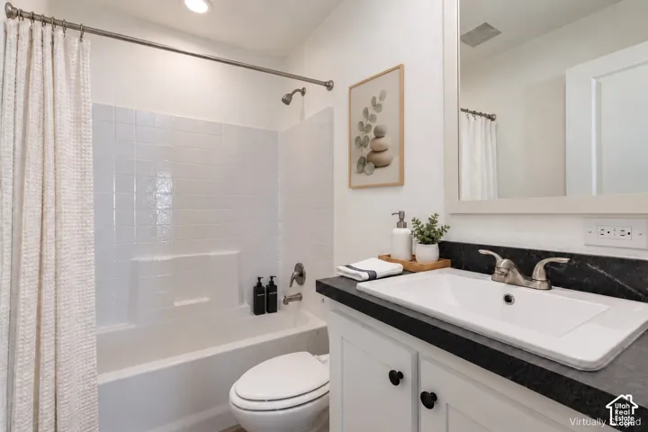 White vanity with black countertop, undermount sink, and brushed nickel fixtures