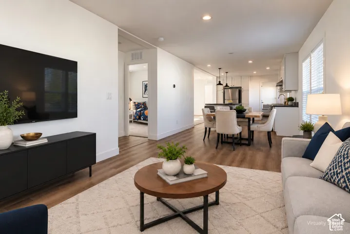 Open-concept living area featuring wood-finish flooring, recessed lighting, and white walls