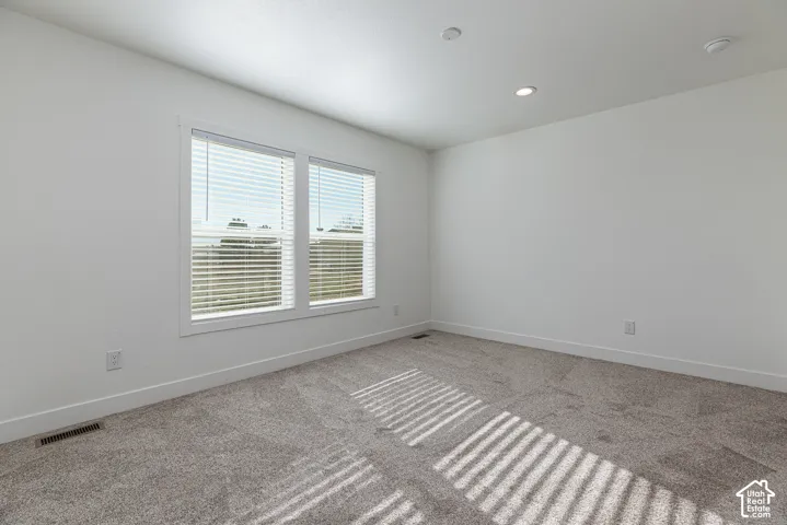 Primary Bedroom Bright interior space featuring recessed lighting, plush carpet flooring, and dual windows
