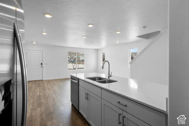 Kitchen island with an undermount dual-basin sink, stainless steel faucet, and light-toned countertop
