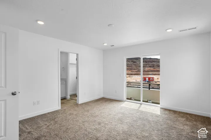 Recessed lighting and a sliding glass door opening to a private balcony