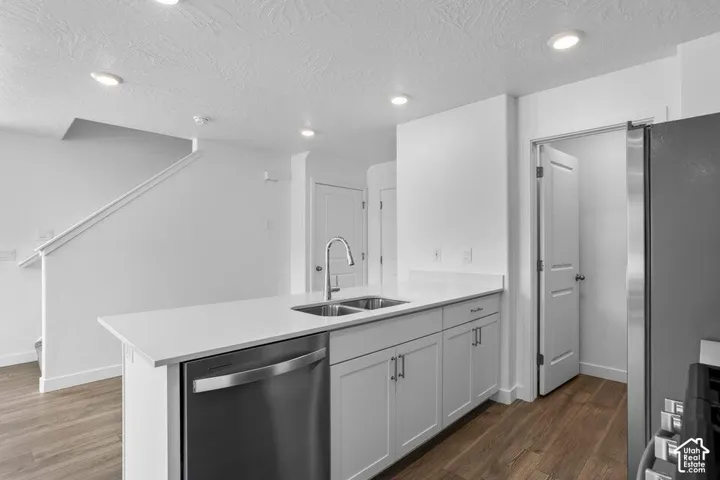 Kitchen island featuring a double-basin sink and stainless steel dishwasher