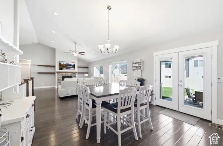 Vaulted ceilings, wood-finish flooring, stone fireplace, recessed lighting, and French doors