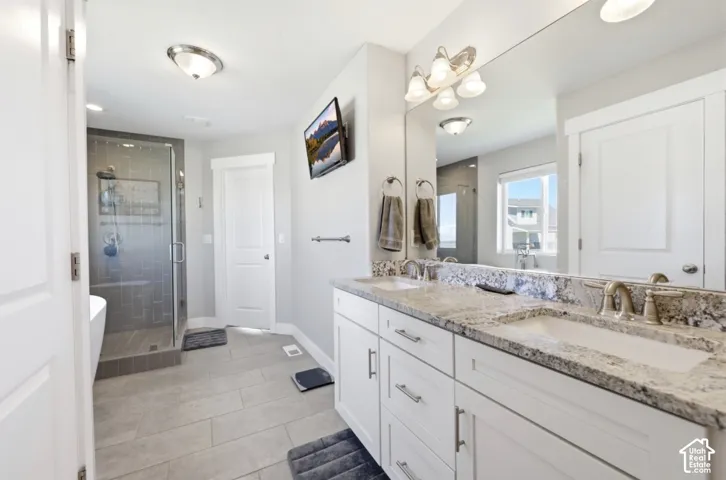 Dual vanity with light-toned countertop, ample storage cabinetry, and mounted mirror