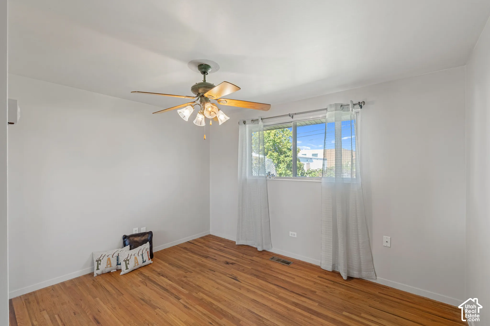 Hardwood flooring, ceiling fan with light fixture, window with natural light