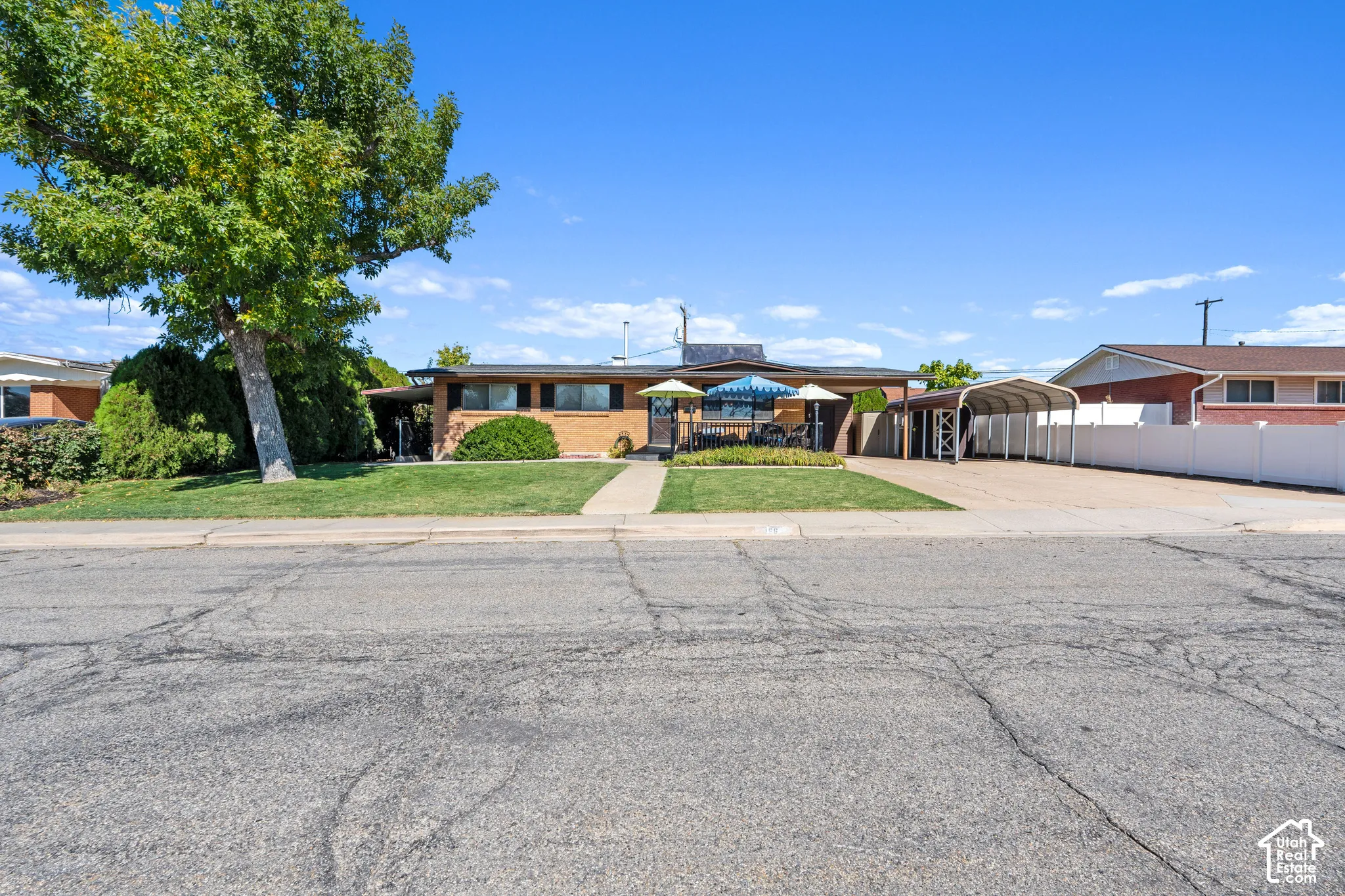 Brick exterior, covered patio, front lawn, mature tree, extended driveway