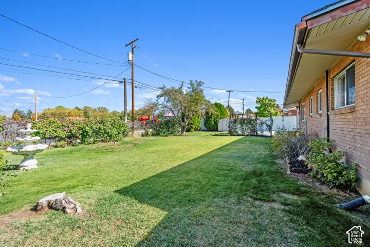 Expansive green lawn, brick exterior, multiple windows, stone-finish fountain, and established landscaping