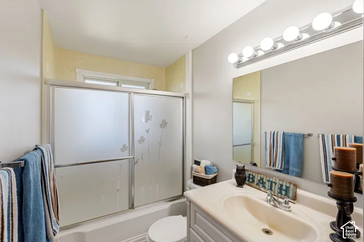 Bathtub with frosted glass sliding doors, single vanity with integrated sink, chrome faucet, and a wall-mounted mirror