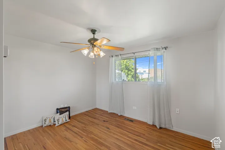 Hardwood flooring, ceiling fan with light fixture, window with natural light