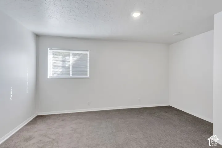 Recessed lighting, wall-to-wall carpeting, and a window with blinds